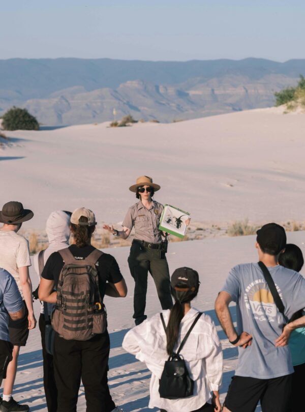 Group of tourists with a guide exploring White Sands National Park during daytime.