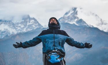 A man embraces the freedom of the mountains in Ghode Pani, Nepal.