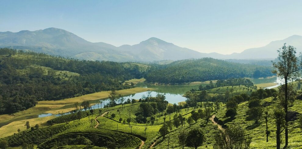 A breathtaking aerial view of Munnar, India, showcasing lush tea plantations and a serene river.