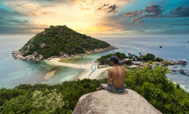Man admiring breathtaking sunset view of Koh Nang Yuan Island in Thailand.