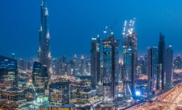 A breathtaking aerial view of Dubai's skyline with Burj Khalifa lit at night.