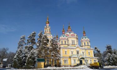 Scenic winter view of Zenkov Cathedral surrounded by snow-covered trees in Almaty, Kazakhstan.