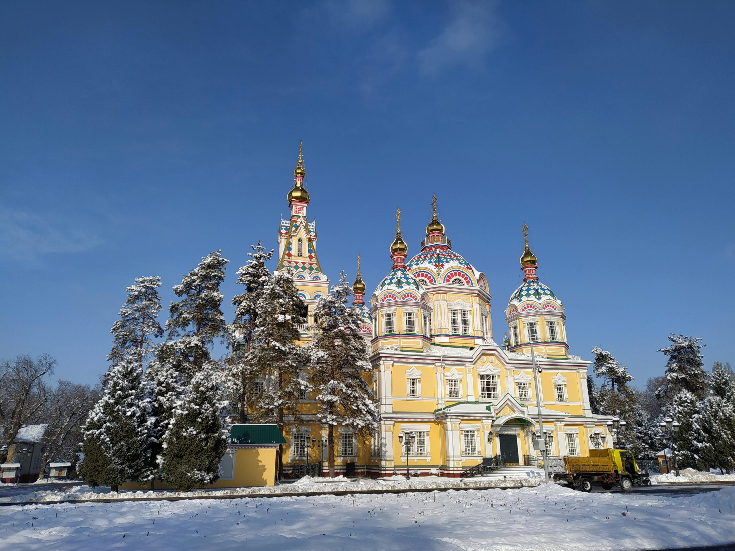 Scenic winter view of Zenkov Cathedral surrounded by snow-covered trees in Almaty, Kazakhstan.
